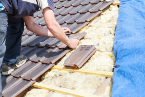 Roofer putting tiles on roof